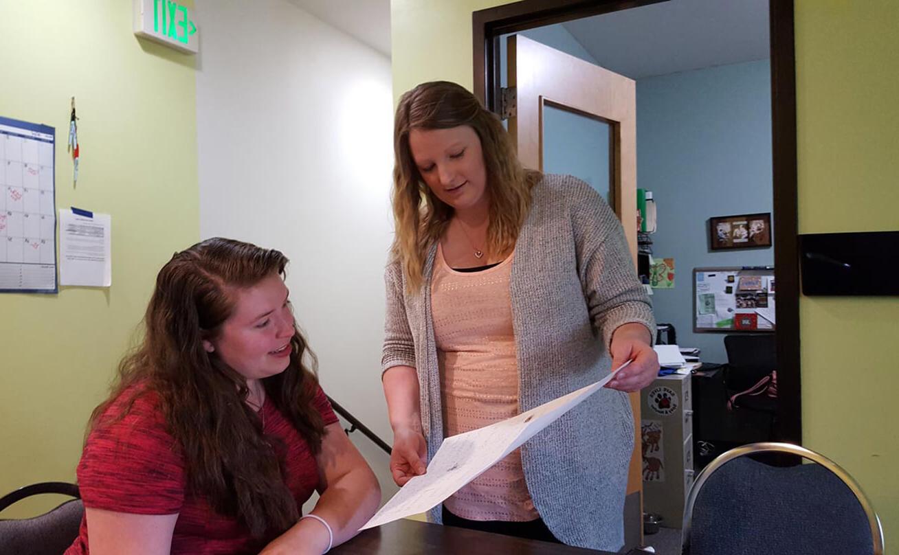 Two women review work in class