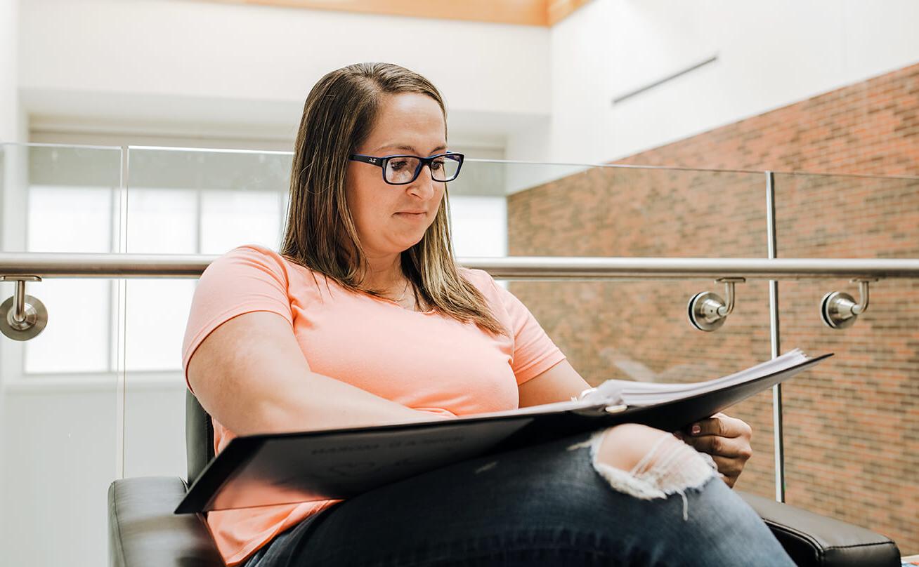 Female student studying and looking at binder